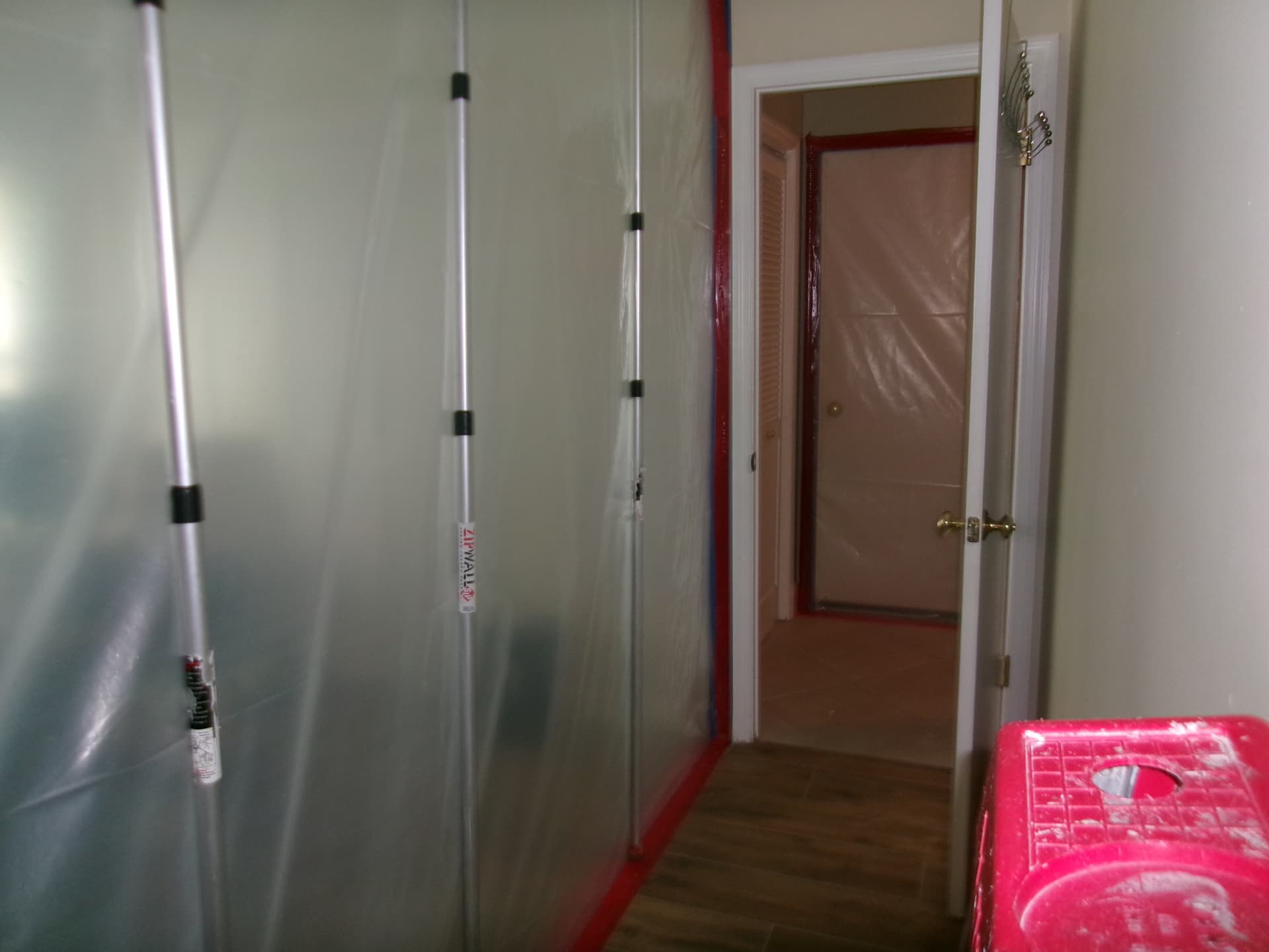 Technician applying antimicrobial treatment to a ceiling corner with a pole-mounted cloth