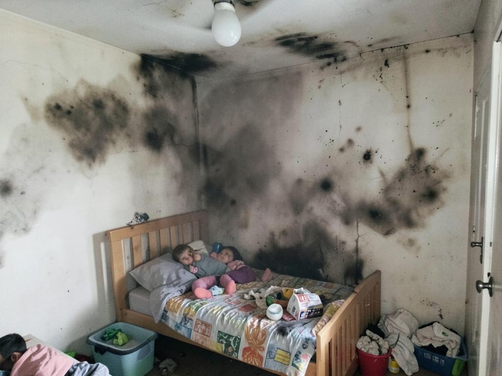 Bedroom wall scorched by an electrical fire with smoke staining